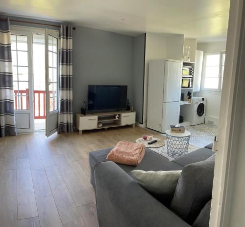 a living room with a couch and a tv at Appartement vue sur la Rhune in Sare