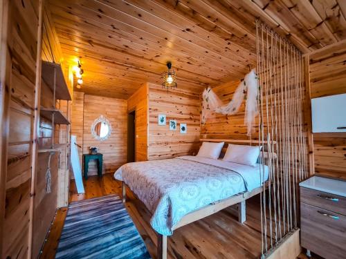 um quarto com uma cama num chalé de madeira em Dagevi Butik Apart em Uzungol