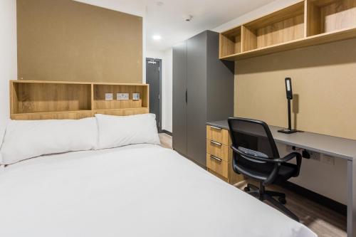 um quarto com uma cama, uma secretária e uma cadeira em Destiny Student - Ardee Point em Dublin