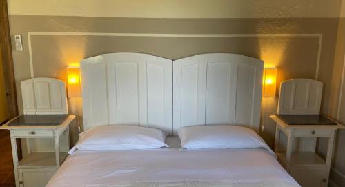 a white bed with two nightstands next to it at Country House Le Case Coloniche in Deruta