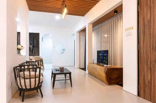 a living room with a chair and a television at Urbanisia in Betek