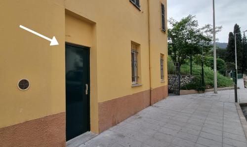 Un edificio amarillo con una puerta con una flecha. en Studio de charme climatisé Gare Riquier, en Niza