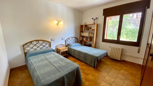 um quarto com duas camas e uma estante de livros em Casa Rústica Cristina em Calafat