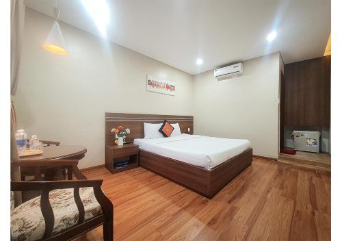 1 dormitorio con cama, escritorio y mesa en Quan Quan Hotel, en Da Nang