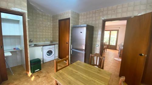 uma cozinha com uma mesa e um frigorífico de aço inoxidável em Casa Rústica Cristina em Calafat