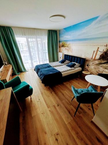 a bedroom with a bed and a table and chairs at Porta Mare Marine in Dziwnów