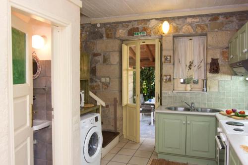 a kitchen with a sink and a washing machine at Drakos Vacation Houses in Stoupa