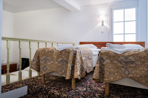 a bedroom with two beds and a staircase at Three Crowns Residents in Tallinn
