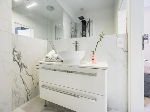 a white bathroom with a sink and a mirror at Charmante Suite für entspannte Tage in Bad Camberg