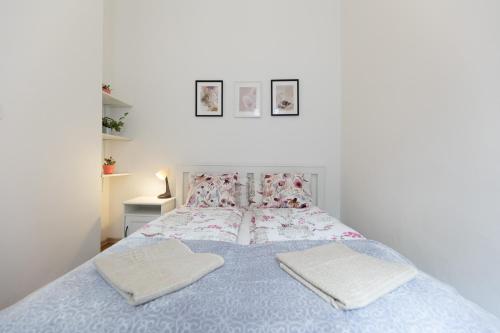 een slaapkamer met een bed met 2 kussens erop bij Emily's Lovely Place in Boedapest