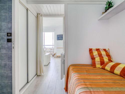 a bedroom with a bed with an orange blanket at Appartement Hendaye, 1 pièce, 3 personnes - FR-1-2-392 in Hendaye
