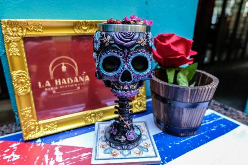 a skull vase next to a flower pot and a picture at The Quba Boutique Hotel Pattaya in Pattaya Central