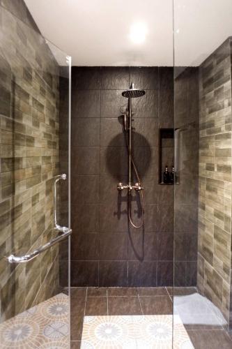 a bathroom with a shower with a glass door at The Quba Boutique Hotel Pattaya in Pattaya Central