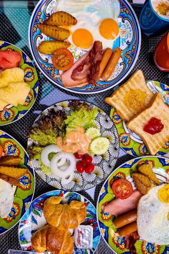 a table with plates of breakfast food on it at The Quba Boutique Hotel Pattaya in Pattaya Central