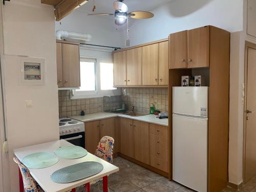 une cuisine avec des armoires en bois et un réfrigérateur blanc dans l'établissement Aphrodite-Recently Renovated Modern Apartment, à Athènes