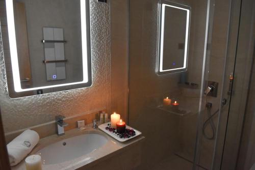 a bathroom with a tub with candles and a mirror at Alibi S in Zlatibor