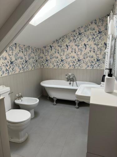 a bathroom with a tub and a toilet and a sink at Mantilly holiday gite in Mantilly