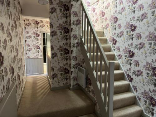 a staircase in a home with floral wallpaper at Mantilly holiday gite in Mantilly