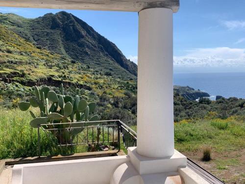 a porch with a cactus on a hill with the ocean at La casa blu superior in Lipari