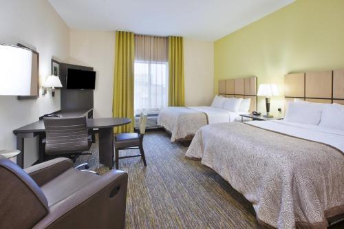 a hotel room with two beds and a desk at Candlewood Suites Morgantown-Univ West Virginia by IHG in Morgantown