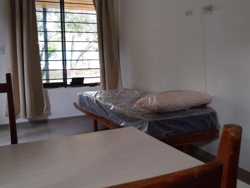 Habitación con cama, mesa y ventana en El Andaluz en San Marcos Sierras