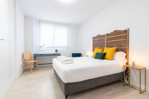 a bedroom with a large bed with yellow pillows at INSIDEHOME Ciudad de Valladolid in Valladolid