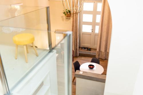 een woonkamer met een tafel en een gele stoel bij Appartamento moderno Second House Catania 26 in Catania