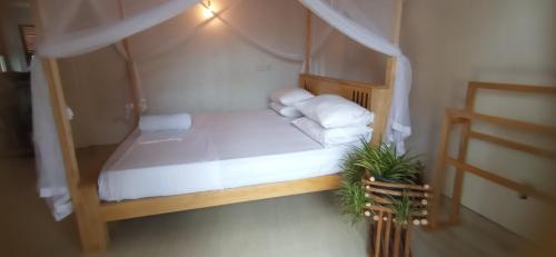 a small bedroom with a bed with white sheets and pillows at Happy Stay Villa (Apartment) in Ahangama