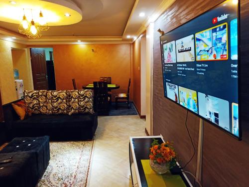 a living room with a couch and a large screen at JJ homes 3 bedroom @Regal point apartments in Nairobi