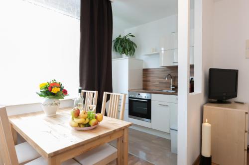 eine Küche mit einem Tisch und einer Obstschale darauf in der Unterkunft Rafael Kaiser - Apartment Cityflow in Graz