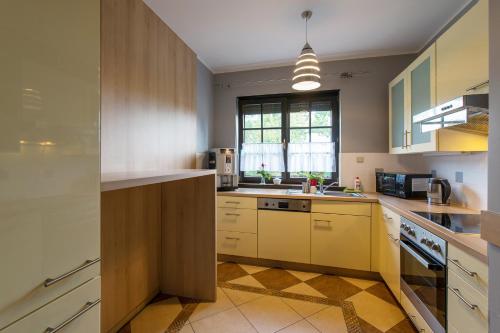 a large kitchen with yellow cabinets and a window at Breeze Guest House in Psary