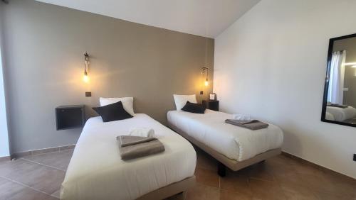two beds in a hotel room with a mirror at Oura Villa V2 Jacarandá in Albufeira