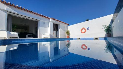 a swimming pool in front of a house at Oura Villa V2 Jacarandá in Albufeira