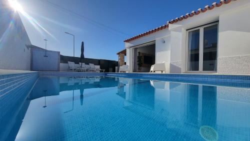 a villa with a swimming pool next to a house at Oura Villa V2 Jacarandá in Albufeira