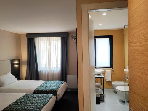 Cette chambre comprend deux lits et une salle de bains. dans l'établissement Hotel Restaurant Forum, à Beausoleil