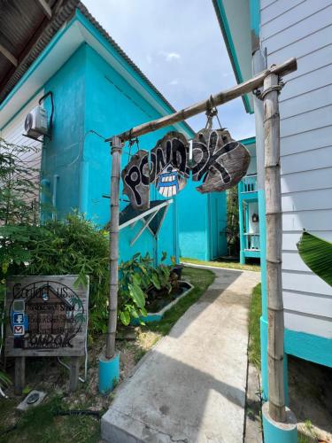 a blue house with a sign that says garden at Dormitory Pondok in Tioman Island