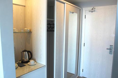 a kitchen with a cupboard and a mirror in a room at Shellghada Blue Beach in Hurghada