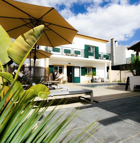 una casa con un patio con una panchina e un ombrellone di Casa Idalia Boutique Hotel a Comporta