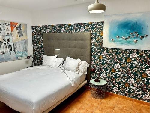 a bedroom with a bed with a floral accent wall at Sol Port Soller in Port de Soller