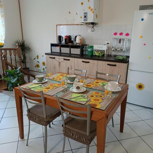 a dining room table with chairs and a kitchen at B&B I Girasoli in San Donato Milanese