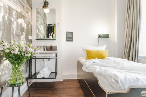 a bedroom with a bed and a vase of flowers at Pyjama Park St Pauli Hotel und Hostel in Hamburg