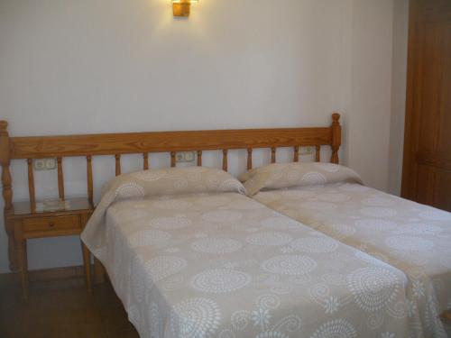 a bedroom with two beds and a night stand at Apartamentos Can Jordi in Cala Figuera