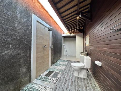 a bathroom with a toilet and a walk in shower at Villa Vilah in Nusa Penida