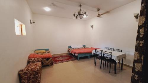 a room with two beds and a table and chairs at Sufi Khandar Home Stay in New Delhi