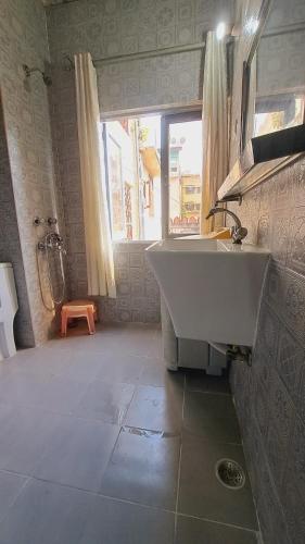 a bathroom with a large sink and a window at Sufi Khandar Home Stay in New Delhi