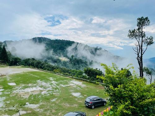 a car parked in a field in front of a mountain at Sports Homestay in Lansdowne