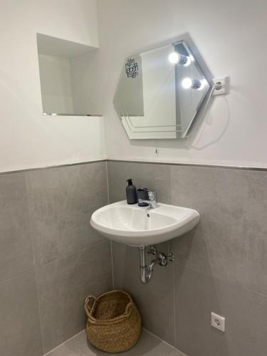 ein Badezimmer mit einem weißen Waschbecken und einem Spiegel in der Unterkunft Klytti‘s Pension in Sendenhorst