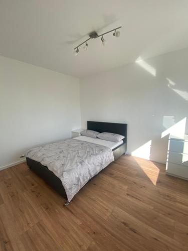 1 dormitorio con 1 cama en una pared blanca en Klytti‘s Pension, en Sendenhorst