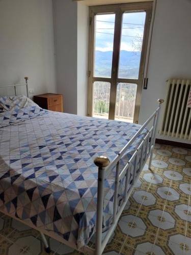 a bedroom with a bed and a large window at Casa Adélona in Ofena
