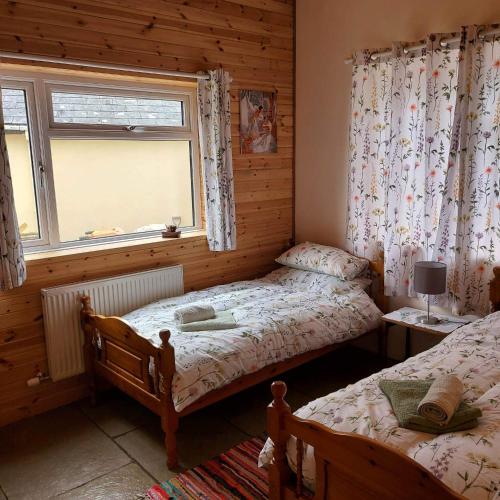 a bedroom with two twin beds and a window at Spacious self catering accommodation near HayOnWye in Hay-on-Wye